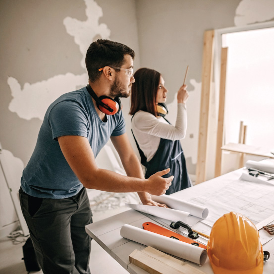 Image of two people wearing safety gear in a house under construction