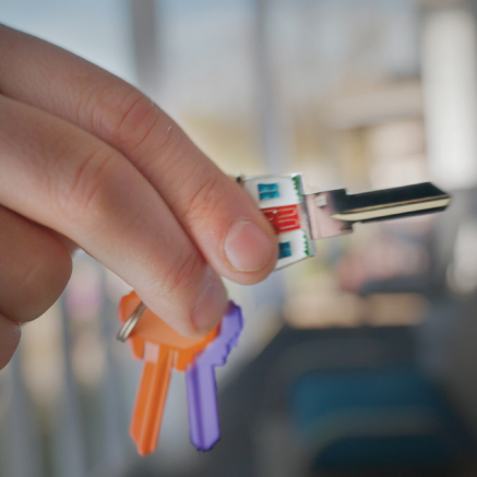 Person holding orange and purple keys