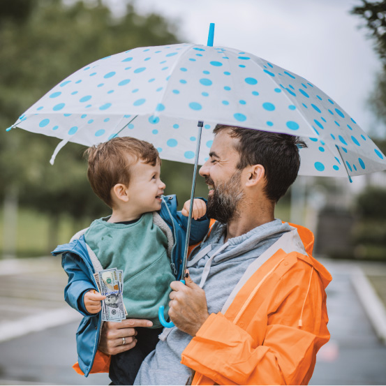 Man holding umbrella over child