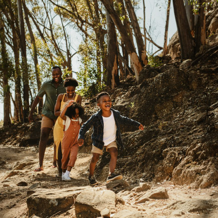 A man, woman, and two children run outdoors