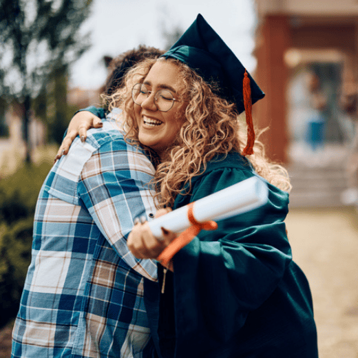 Blonde woman diploma and hugging dad at graduation
