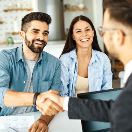 Image of three people in an office, two are shaking hands