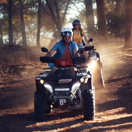 Image of two people riding ATVs