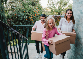 Image of a family carrying boxes into a new home