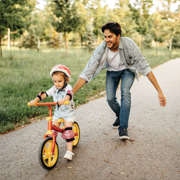 Dad teaching daughter how to ride a bike