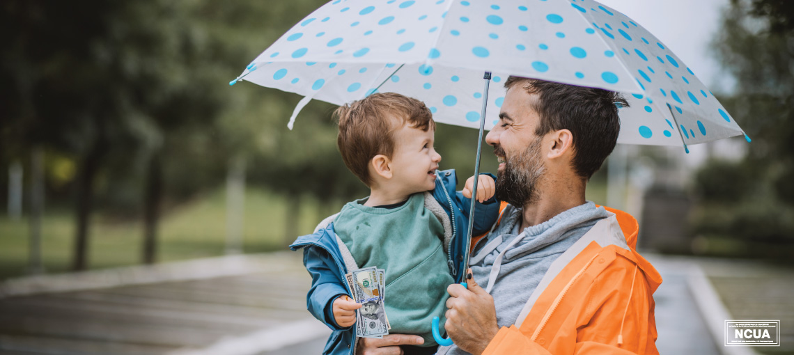 Man holding child under umbrella.