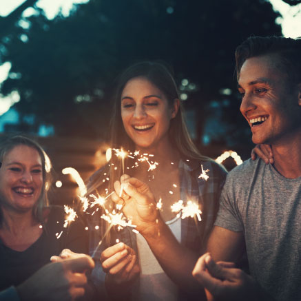 Group of young adults holding sparklers in celebration