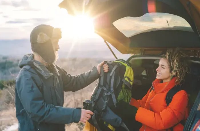 Couple unpacking trunk of car