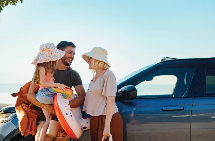 Family next to car by beach