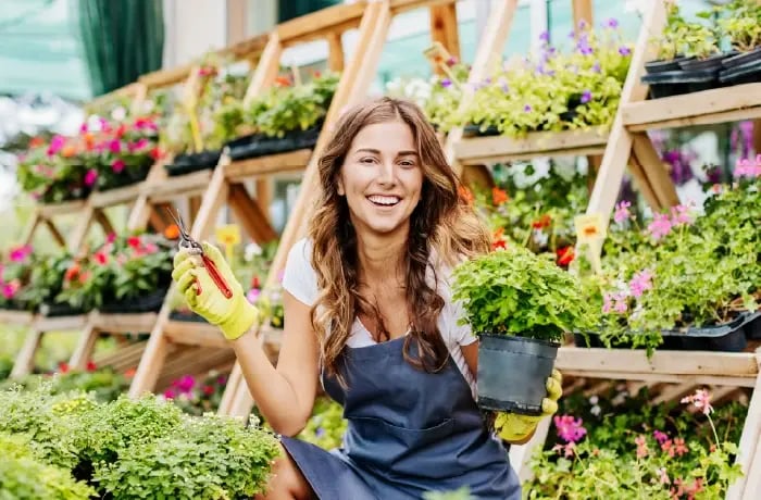 Greenhouse Owner smiling infront of plants