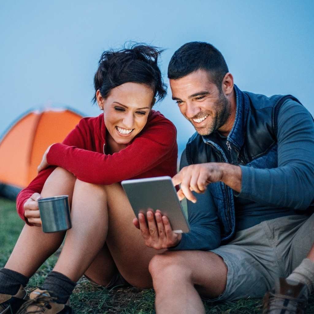 Man and woman smiling at tablet