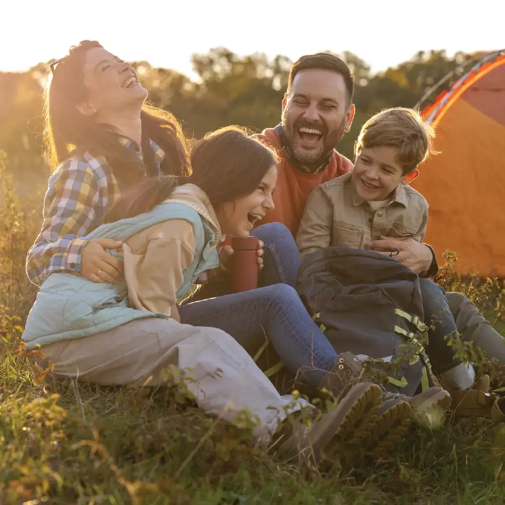 Family laughing in the grass