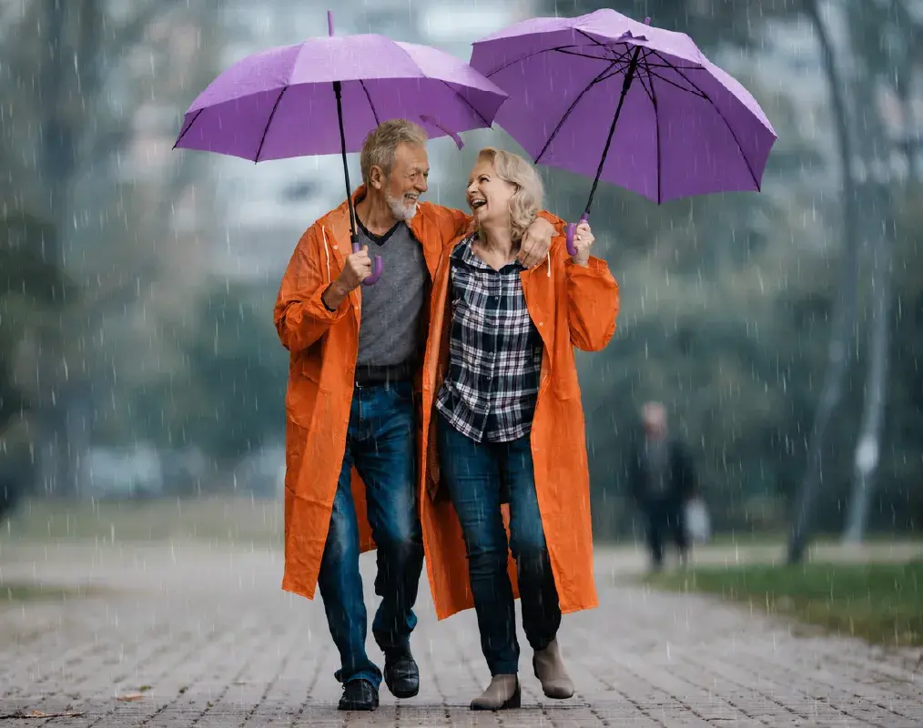 Mature couple in laughing in the rain